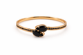 Gold bracelet with black gemstones on a white background