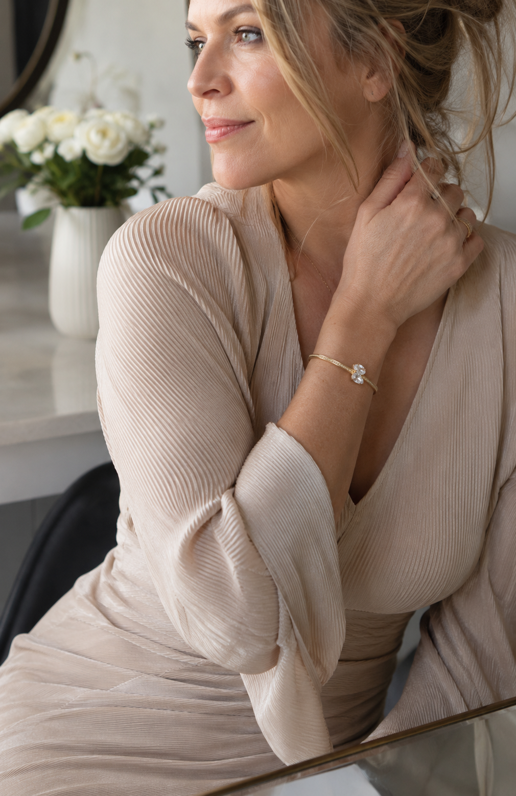 bracelet with a beige blouse in natural light. Luxury bridal-inspired jewelry photography by Mancerat.