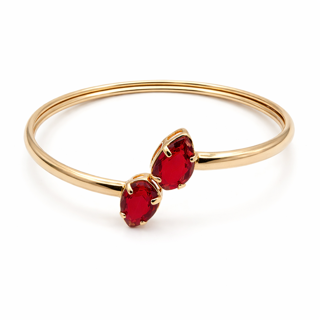 Elegant gold open cuff bracelet featuring two deep red marquise-cut gemstones in an open crossover design. Minimalist gold bracelet photographed on a pure white background for a modern luxury jewelry collection.