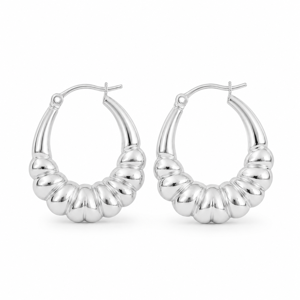 Pair of polished sterling silver chunky ribbed hoop earrings standing upright on a pure white background with a modern sculptural design.