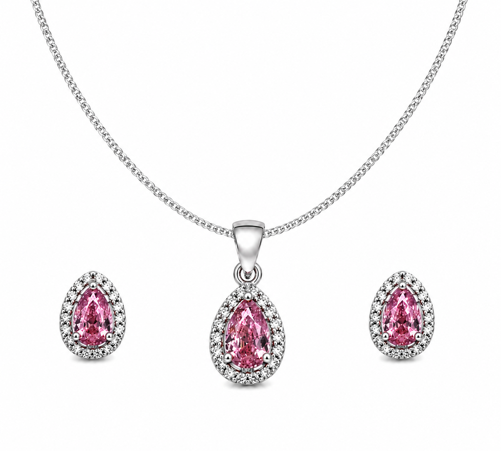 Sterling silver jewelry set featuring a pear-cut pink cubic zirconia halo pendant necklace on a thin curb chain with matching pink halo stud earrings on a pure white background