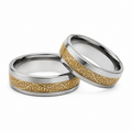 Two-tone tungsten ring featuring intricate gold scroll inlay detailing with polished silver-tone edges on a clean white background.